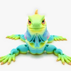 May include: A multi-colored articulated iguana figurine featuring a gradient of lime green, bright yellow, and cyan blue. The lizard has a textured, scaly surface, a prominent dewlap under its chin, and articulated limbs with clawed feet.