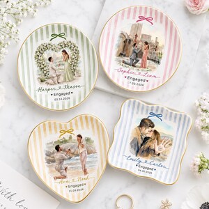 Puede incluir: Cuatro platos de cerámica con ilustraciones personalizadas de parejas comprometidas. Cada plato muestra una escena única, nombres, el texto Engaged y una fecha. Los diseños incluyen patrones de rayas en verde, rosa, amarillo y azul.