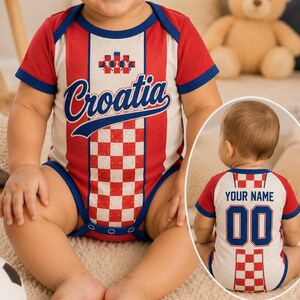 K&ouml;nnte beinhalten: Ein kurz&auml;rmeliger Baby-Body mit rot-wei&szlig;em Karomuster und blauen R&auml;ndern. Auf der Vorderseite steht der Schriftzug Croatia in blauer Schreibschrift. Die R&uuml;ckseite zeigt den Text YOUR NAME &uuml;ber der Zahl 00 in blauen Blockbuchstaben.