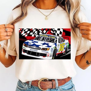 May include: A white t-shirt with a graphic of a race car, number 16, with a blue star pattern on the hood. The words "NATIONAL GUARD" are visible. The background features a checkered flag design in red, black, and white.