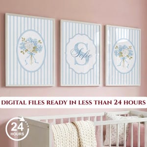 May include: Three framed wall art prints featuring a light blue and white vertical striped background. Two outer prints display a blue hydrangea bouquet in an oval frame. The center print features a large letter S and the name Sofie.