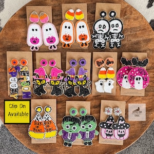 May include: Assortment of Halloween themed beaded earrings.  The earrings feature various designs including ghosts, pumpkins, skeletons, bats, witches, and candy corn.  The earrings are available in a variety of colors, including black, white, orange, purple, and pink.  The earrings are clip-on.
