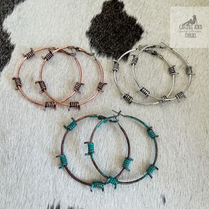 May include: Three pairs of hoop earrings with a barbed wire design. The earrings are available in silver, copper, and turquoise.