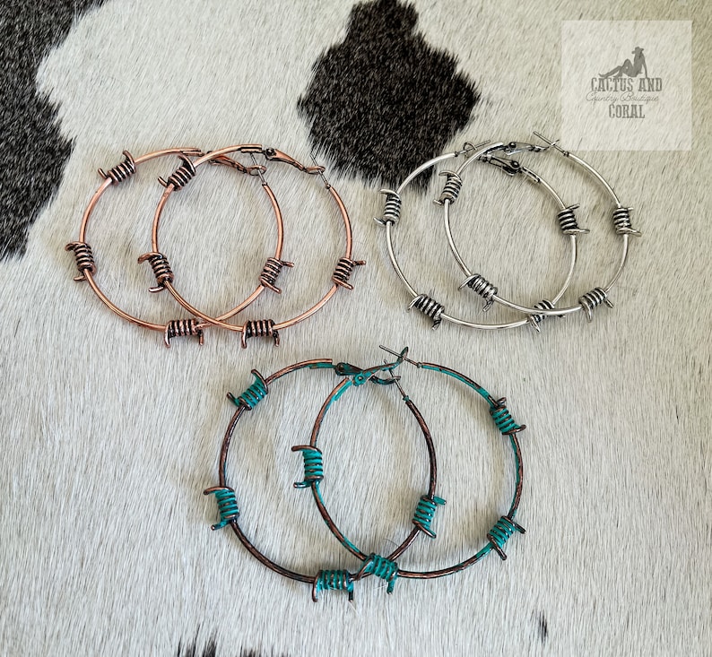 May include: Three pairs of hoop earrings with a barbed wire design. The earrings are available in silver, copper, and turquoise.