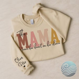 This Mama Wears Her Heart on Her Sleeve Hoodie – Custom Names on Sleeve – Mother’s Day Gift, Personalized Mom Sweatshirt, Cute Mom Gift Idea