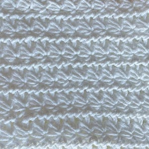 May include: White crocheted fabric with a repeating star pattern.