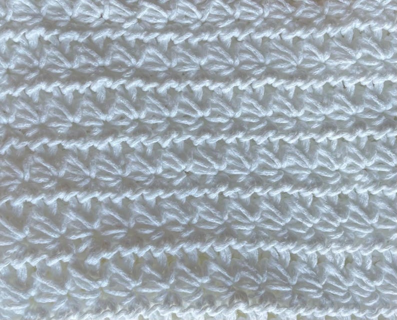 May include: White crocheted fabric with a repeating star pattern.