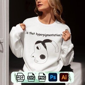 May include: White sweatshirt with the text "is that hyperpigmentation?" above a black and white cartoon face. The sweatshirt is a crew neck style.