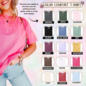 May include: A short-sleeved t-shirt in a bright pink color, paired with light blue jeans. The image displays a color chart titled COLOR COMFORT T-SHIRT, featuring fifteen different shirt color options labeled Pepper, Moss, Blossom, Black, Blue Jean, Bay, Berry, Orchid, Mustard, Espresso, White, Crunchberry, Ivory, Crimson, and Chambray.