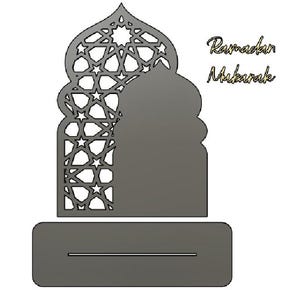 May include: A grey laser-cut Ramadan decoration. The design features an arched silhouette with a star pattern, a solid mosque shape, and a rectangular base with a slot. The words "Ramadan Mubarak" are written in a script font.