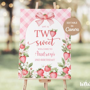Könnte beinhalten: Ein rosa-weiß kariertes Willkommensschild auf einer Staffelei. Auf dem Schild steht "She is Two Sweet, Welcome to Audrey's 2nd Birthday". Das Design umfasst Erdbeer-Illustrationen und eine Schleife.