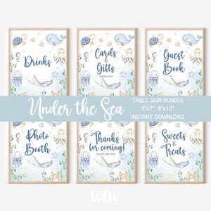 May include: A set of six framed signs with an "Under the Sea" theme. Each sign features watercolor illustrations of sea creatures like whales, jellyfish, and stingrays. Text includes "Drinks," "Cards & Gifts," "Guest Book," "Photo Booth," "Thanks for coming!," and "Sweets & Treats."