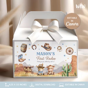 Puede incluir: Caja de regalo blanca con un lazo blanco y un panel frontal decorativo. El panel presenta un tema "First Rodeo de Mason" con ilustraciones de un sombrero de vaquero, botas y un vagón. La caja mide 15,88 x 8,89 cm.
