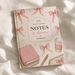 Cuaderno de tapa dura con diseño de lazo rosa y lazo floral.