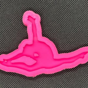 Könnte beinhalten: Rosa Silikonform in Form einer Turnerin in Spagat.