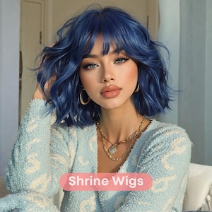 May include: A woman with blue hair and a light blue sweater. The hair is styled in loose waves with bangs. She is wearing gold hoop earrings and a gold necklace. The text "Shrine Wigs" is displayed on a pink banner.