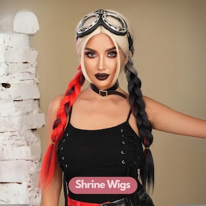 Puede incluir: Una mujer con una peluca rubia con trenzas rojas y negras, que lleva gafas, un collarín negro y una camiseta negra. La imagen incluye el texto "Shrine Wigs" sobre un fondo rosa.