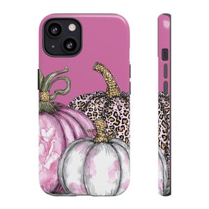May include: A pink phone case featuring a watercolor illustration of three pumpkins. The pumpkins have gold glitter stems and a leopard print design. The case is a vibrant pink color.