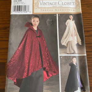 May include: Vintage Closet sewing pattern for a cape, Simplicity pattern number 4947. The pattern includes three different styles of capes: a red velvet cape, a white fur-trimmed cape, and a black velvet cape.