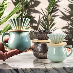 May include: Three ceramic coffee pour-over pots with wooden lids and matching ceramic filters. The pots are light blue and green, and the filters are white and green.