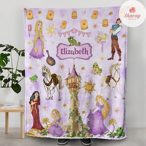 May include: Purple fleece blanket with a personalized name "Elizabeth" in a gold frame. The blanket features characters from the Disney movie Tangled, including Rapunzel, Flynn Rider, and Pascal the chameleon. There are also images of flowers, lanterns, and a tower.