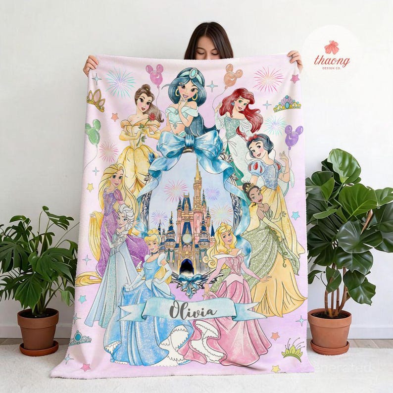May include: A rectangular fleece blanket featuring a light pink background with a central illustration of a castle framed by a large blue bow. Surrounding the castle are various animated princesses, colorful fireworks, and the name Olivia in script.