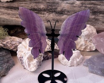 Mariposa tallada en fluorita púrpura con soporte de exhibición.