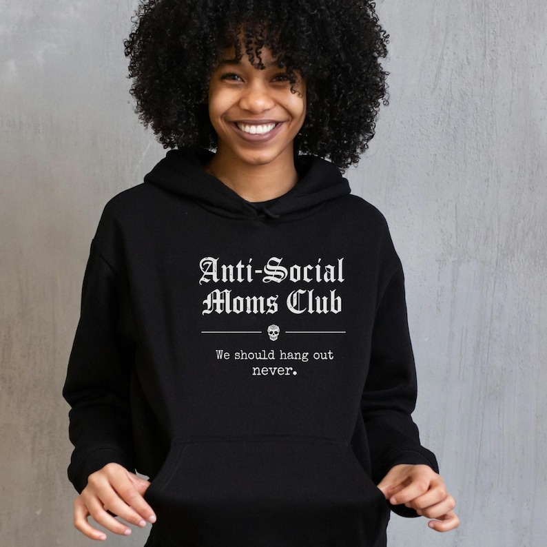 May include: Black hooded sweatshirt with the text "Anti-Social Moms Club" in a gothic font, with a skull graphic and the phrase "We should hang out never."