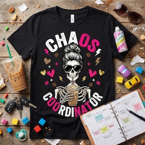 Può includere: T-shirt nero con la scritta "CHAOS COORDINATOR" e una grafica di uno scheletro con occhiali da sole che tiene in mano un caffè. Il design include accenti rosa, cuori e chicchi di caffè.