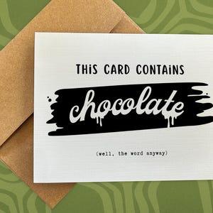 May include: A white greeting card with the text "THIS CARD CONTAINS chocolate" in black, with the word "chocolate" written in a stylized font. The card is inside a brown envelope, set against a green patterned background.