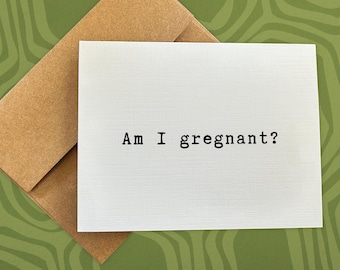 May include: A white card with the text "Am I gregnant?" printed in black typewriter font.