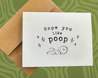 May include: A white card with black text that reads "Hope you like poop" and a cartoon baby sleeping. There are small stars around the baby.
