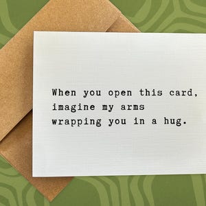 May include: A white card with the text "When you open this card, imagine my arms wrapping you in a hug."