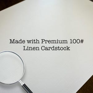 May include: A magnifying glass on a white background with the text "Made with Premium 100# Linen Cardstock".