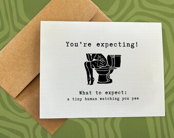 May include: A white card with black text and a black silhouette of a person sitting on a toilet. The text reads "You're expecting! What to expect: a tiny human watching you pee."