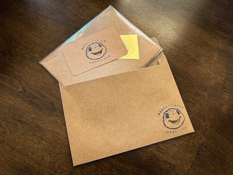 May include: A brown envelope with a smaller brown envelope inside. The smaller envelope has a sticker with a cartoon turtle and the text "Happy Turtle Greetings".