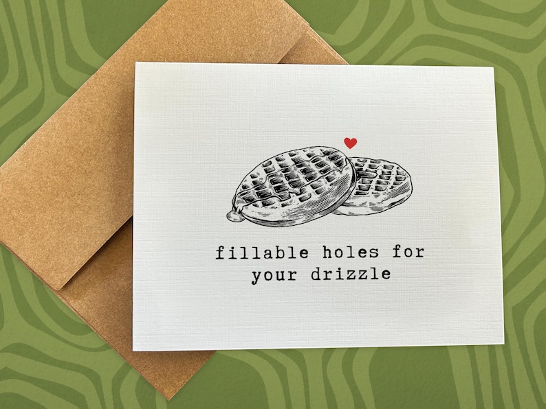 May include: A white card with a black and white illustration of two waffles with the text "fillable holes for your drizzle" printed in black.