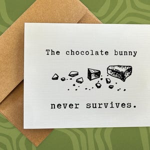 May include: A white card with black text that reads "The chocolate bunny never survives."  The card features a black and white illustration of broken chocolate pieces.