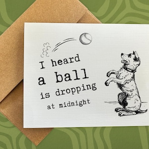 May include: Greeting card with a dog illustration and the text "I heard a ball is dropping at midnight." The dog is standing on its hind legs, looking up at a ball. Includes a brown envelope.
