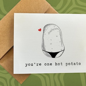 May include: A white card with a black and white illustration of a potato wearing a bikini. The card says "you're one hot potato" in black text.