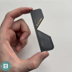 May include: A black 3D printed plastic gauge with a 3.5 mm measurement printed on it.