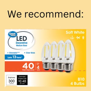 Op de afbeelding: Een verpakking van vier LED decoratieve lampen met een medium fitting. De lampen zijn van helder glas en zacht wit. De verpakking geeft aan dat de lampen dimbaar zijn, 13 jaar meegaan en een equivalent van 40 watt hebben, met slechts 4 watt verbruik. De tekst "We recommend:" staat bovenaan.