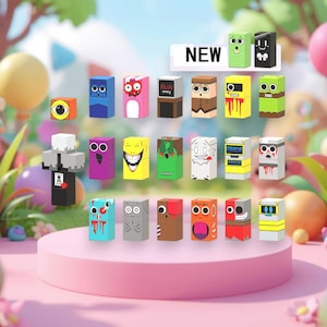 May include: A collection of colorful, cube-shaped toys with various cartoon faces and designs. Some cubes have eyes, mouths, and other features. The word "NEW" is displayed above the toys. The toys are arranged on a pink platform.