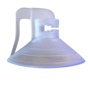 May include: A clear plastic suction cup with a handle. The suction cup has a lip around the edge and a series of concentric rings on the bottom.