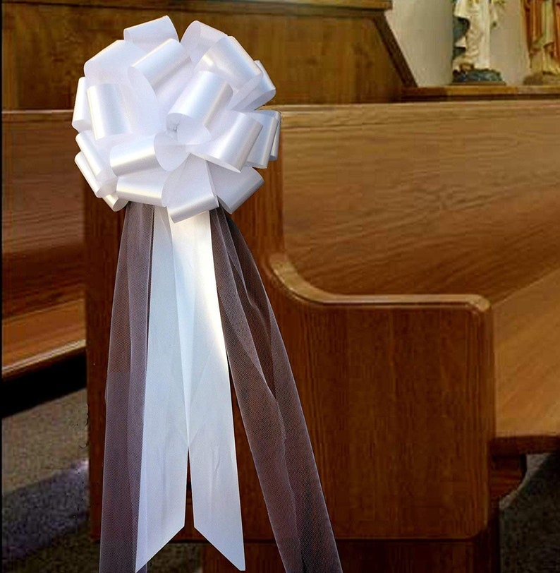 Large white bow with tulle tails displayed on a Church Pew.