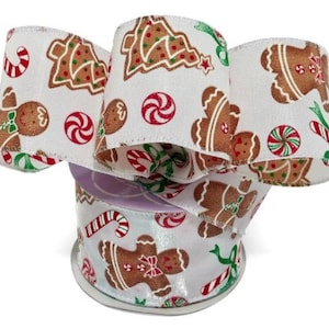 May include: White satin ribbon with a gingerbread man, candy cane, and Christmas tree print. The ribbon is rolled up on a spool.