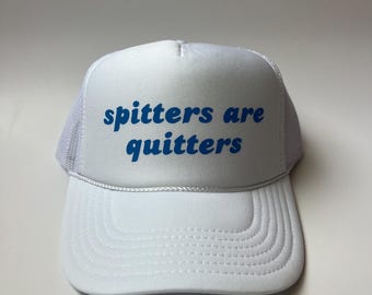 Peut inclure: Casquette de camionneur blanche avec un message brodé en bleu qui dit "spitters are quitters".