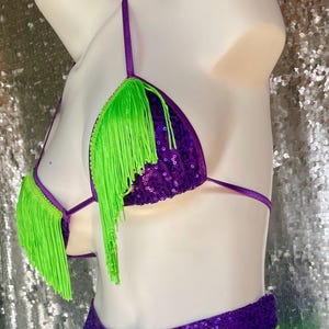 May include: Purple sequined bikini top with lime green fringe trim.