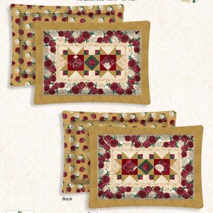 May include: Two queen-size pillow shams with a floral design. The front of the pillows feature a central star pattern with red and white roses, surrounded by a border of roses. The back of the pillow has a pattern of small red and white flowers on a gold background. The text "Crimson Blooms" is at the top.