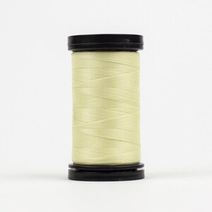 May include: A spool of pale yellow thread wound on a black plastic bobbin.